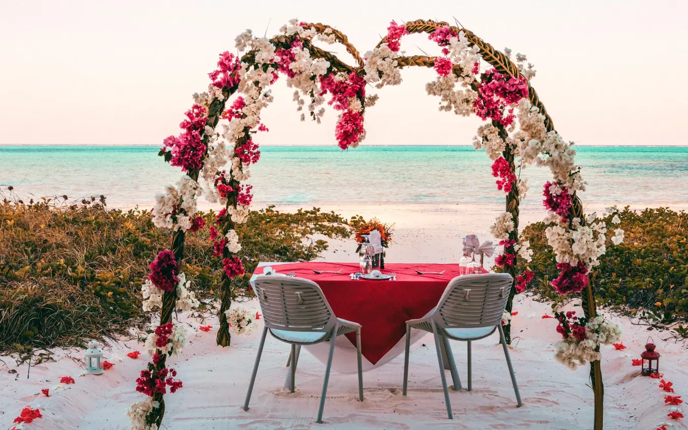 Beach dinner setup with floral arch and turquoise ocean, White Sand Luxury Villas & Spa, Zanzibar & Pemba, Tanzania