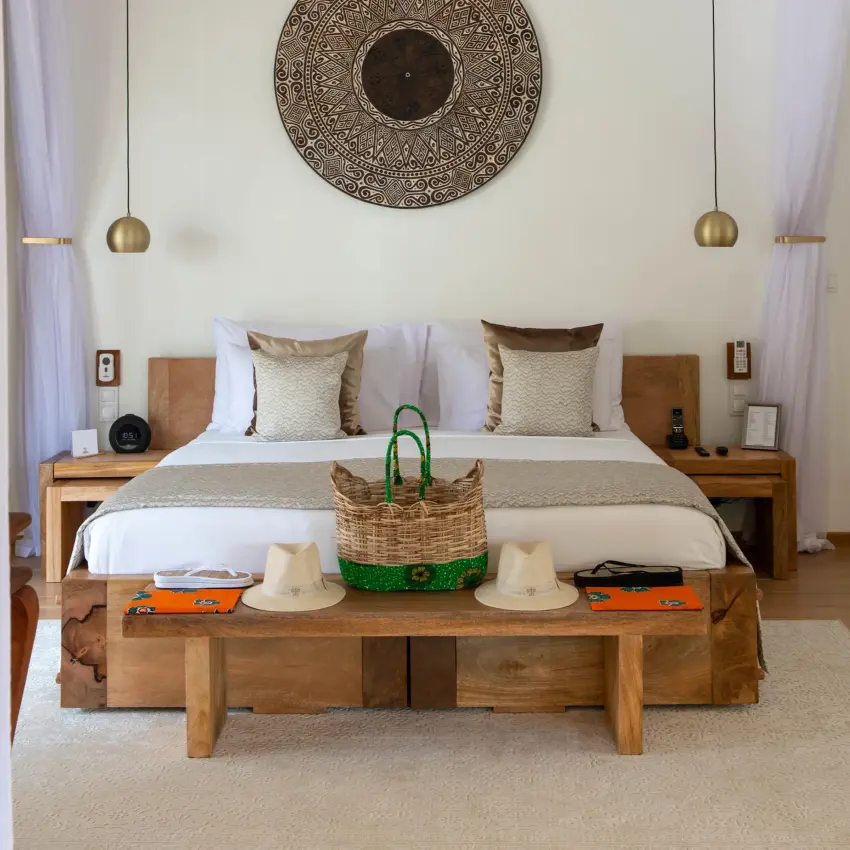Bedroom with wooden bed, pendant lights, and circular wall art, White Sand Luxury Villas & Spa, Zanzibar & Pemba, Tanzania