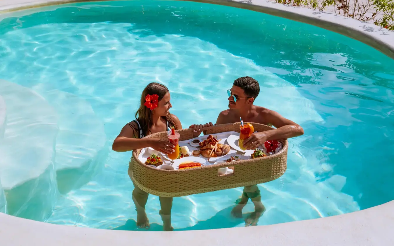 Couple enjoying food and drinks in resort pool, White Sand Luxury Villas & Spa, Zanzibar & Pemba, Tanzania