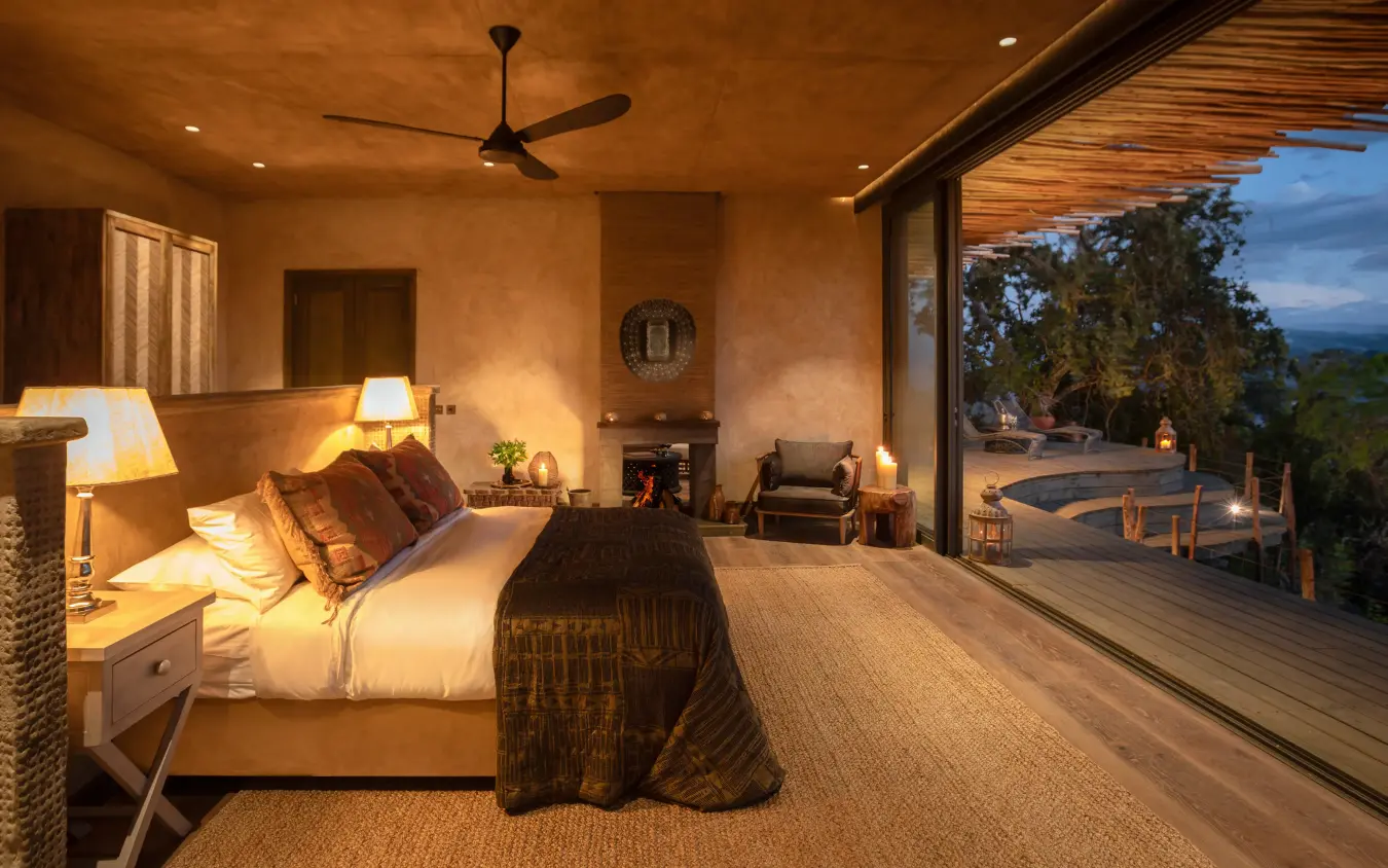 Bedroom with fireplace opening onto sunset deck view, Wild Hill, Maasai Mara, Kenya