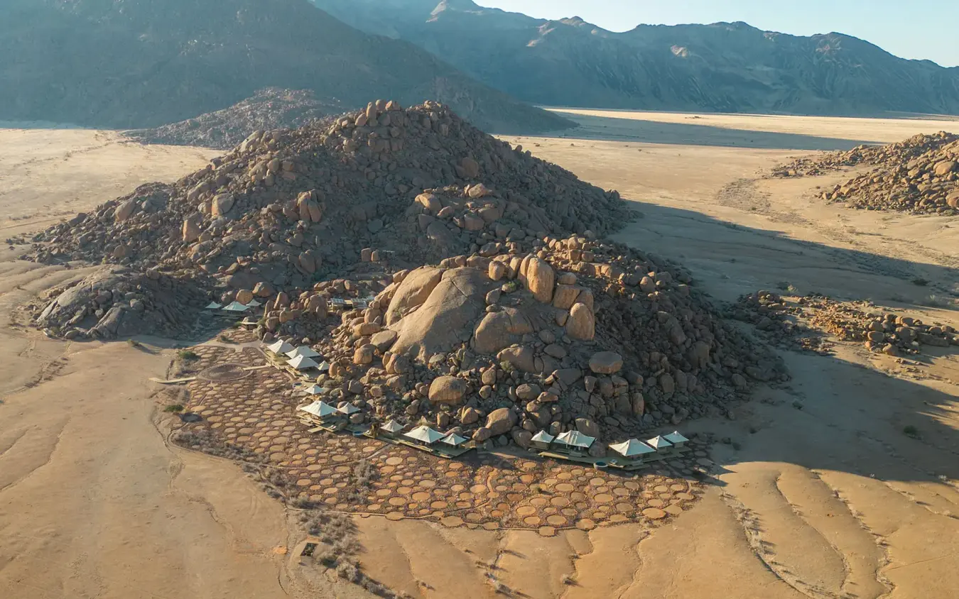 Aerial view of rocky outcrop surrounded by desert landscape, Wolwedans Boulders Camp, NamibRand Private Reserve, Namibia