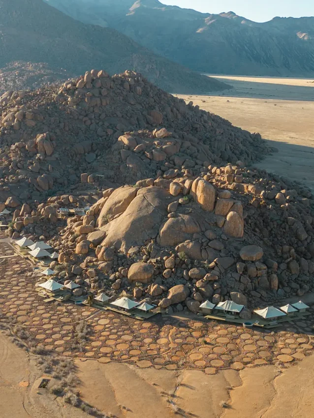Aerial view of rocky outcrop surrounded by desert landscape, Wolwedans Boulders Camp, NamibRand Private Reserve, Namibia