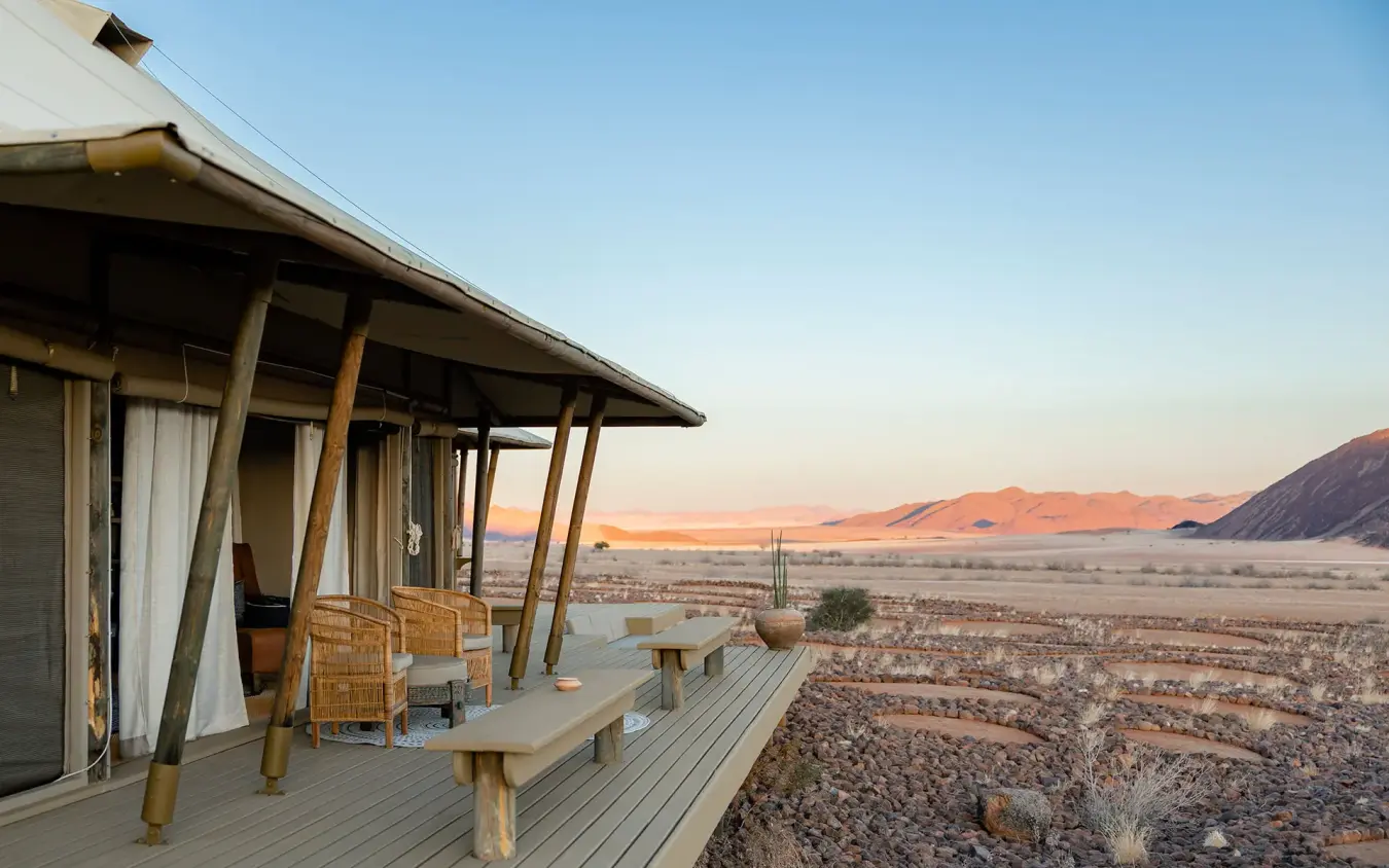 Desert landscape view from lodge wooden deck at sunrise, Wolwedans Boulders Camp, NamibRand Private Reserve, Namibia