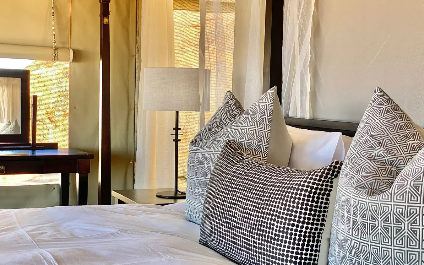 Bedroom with patterned pillows and modern furnishings, Wolwedans Boulders Camp, NamibRand Private Reserve, Namibia