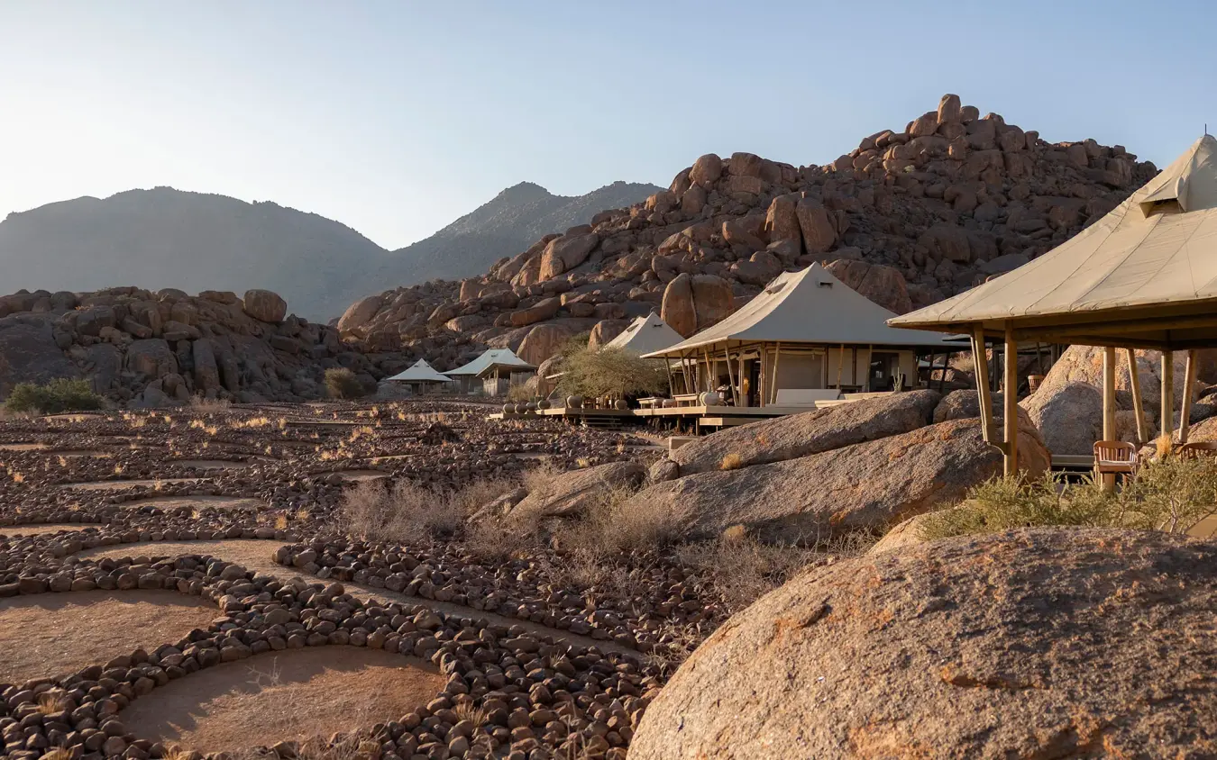 Safari camp tents nestled among granite boulders and mountains, Wolwedans Boulders Camp, NamibRand Private Reserve, Namibia