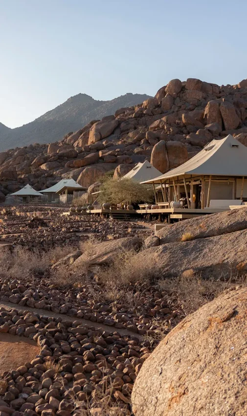 Safari camp tents nestled among granite boulders and mountains, Wolwedans Boulders Camp, NamibRand Private Reserve, Namibia