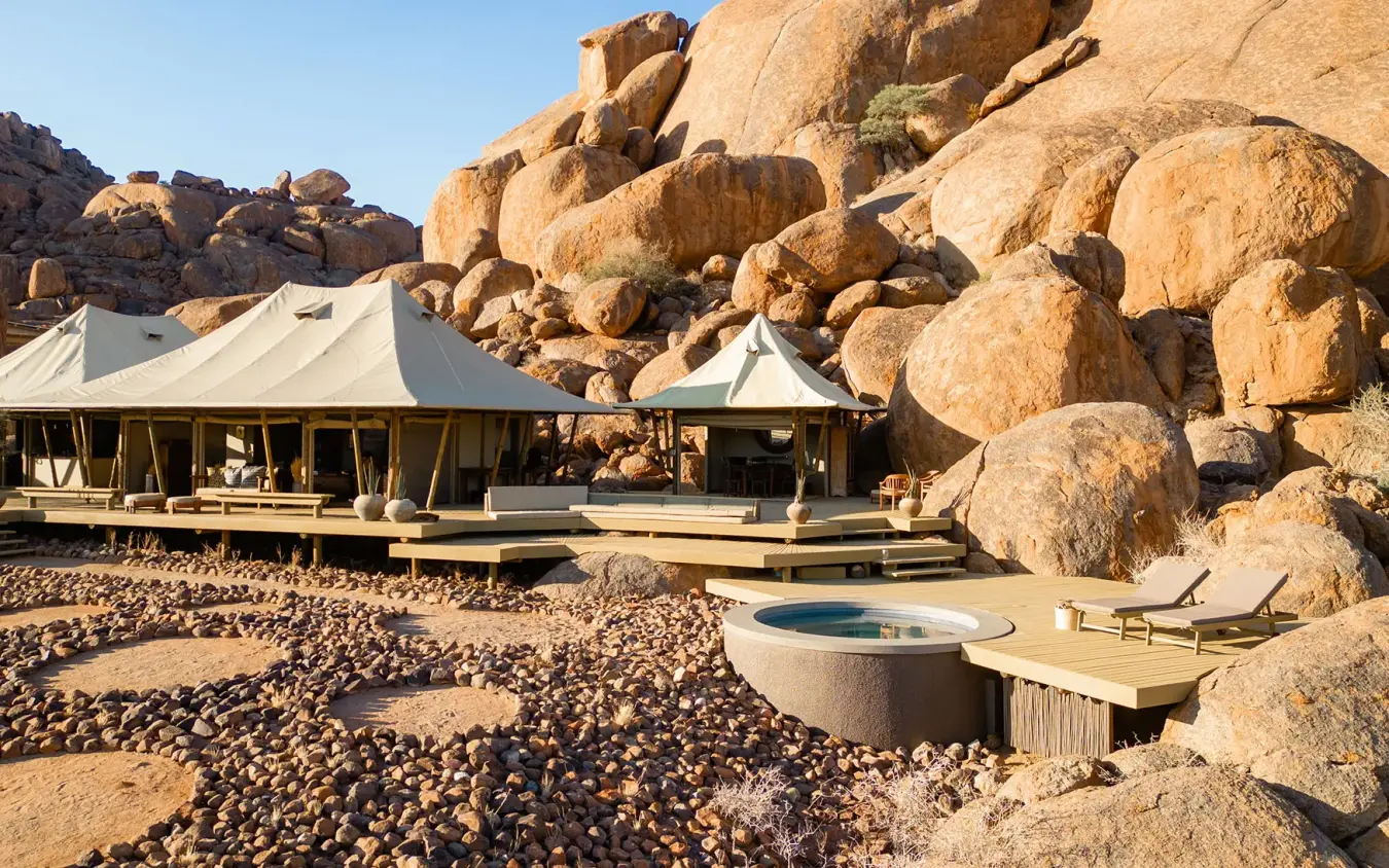 Canvas tent lodge nestled against dramatic boulder rock formations, Wolwedans Boulders Camp, NamibRand Private Reserve, Namibia