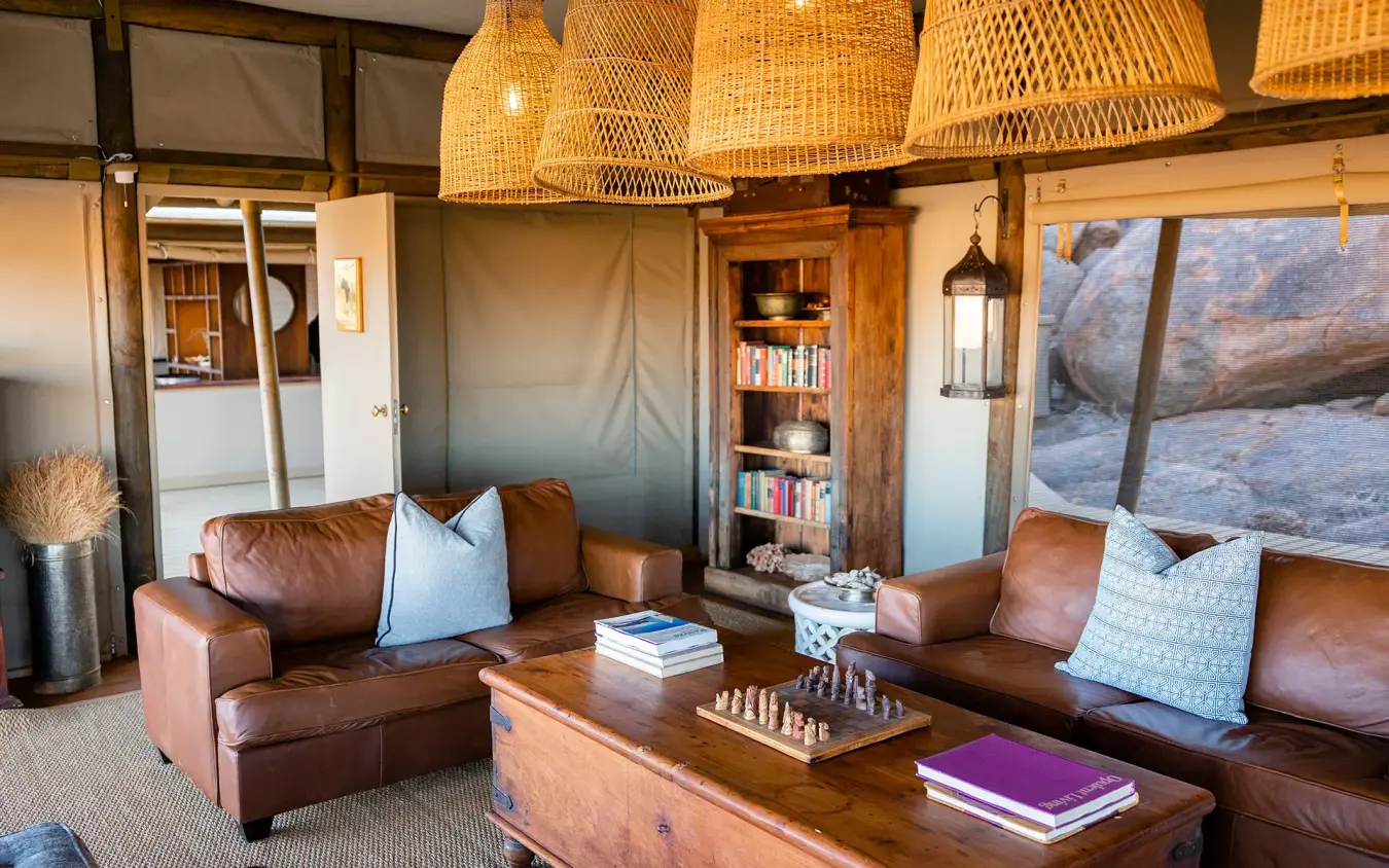 Interior lounge with leather seating and rock views, Wolwedans Boulders Camp, NamibRand Private Reserve, Namibia