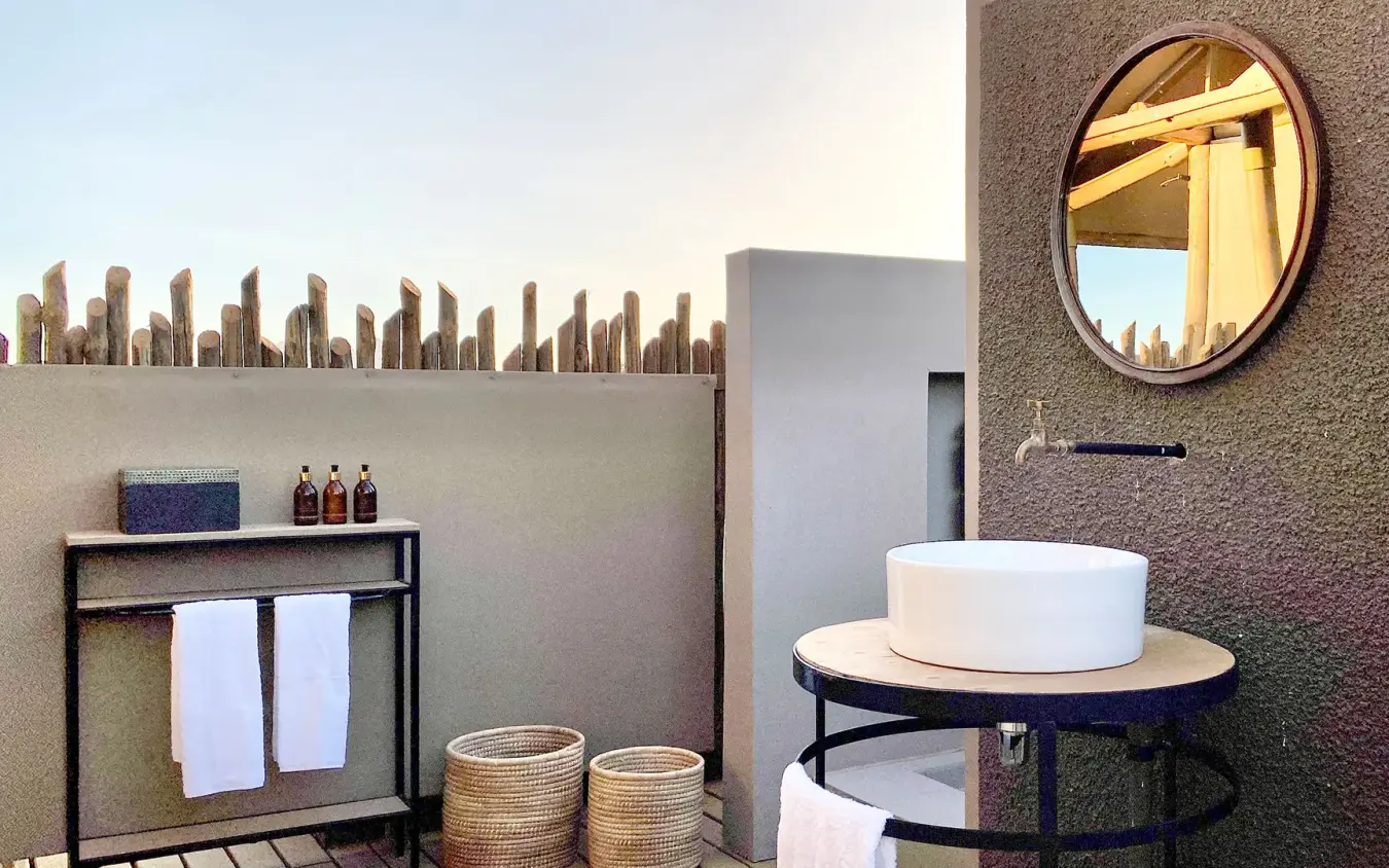 Modern bathroom with round sink and desert-themed wall art, Wolwedans Dune Camp, NamibRand Private Reserve, Namibia
