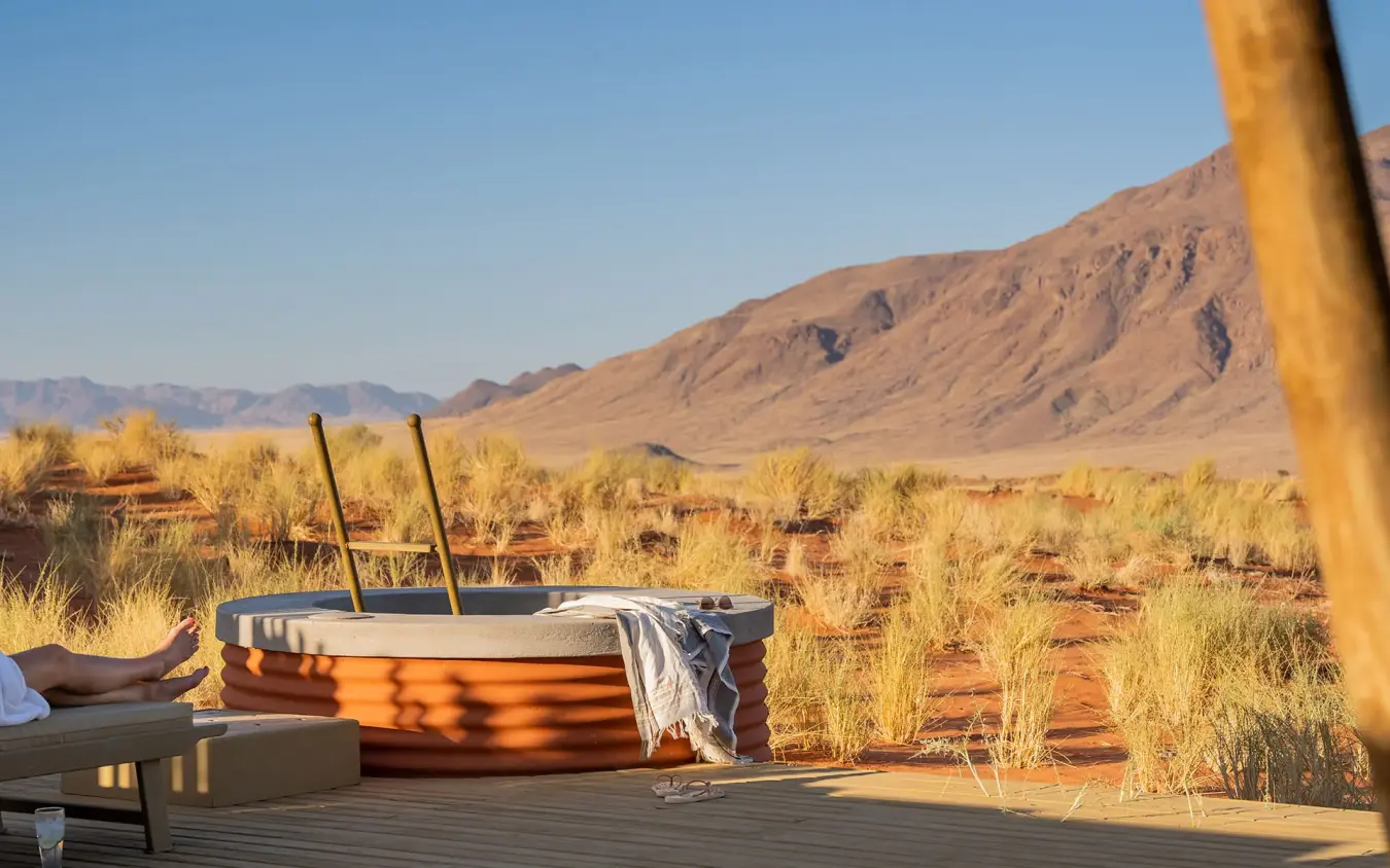Outdoor bathtub on wooden deck overlooking desert landscape, Wolwedans Dune Camp, NamibRand Private Reserve, Namibia