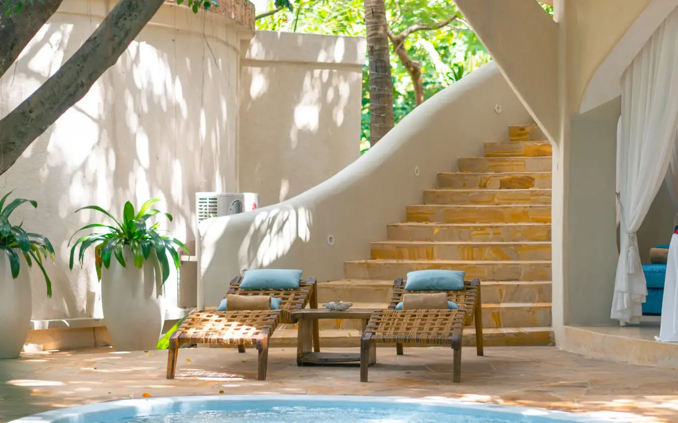Poolside seating area with lounge chairs and stairs, Xanadu Villas, Zanzibar & Pemba, Tanzania