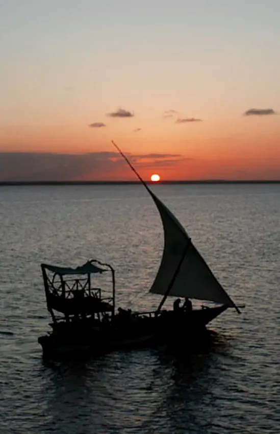 Traditional sailing dhow silhouetted at sunset over calm water, Xanadu Villas, Zanzibar & Pemba, Tanzania