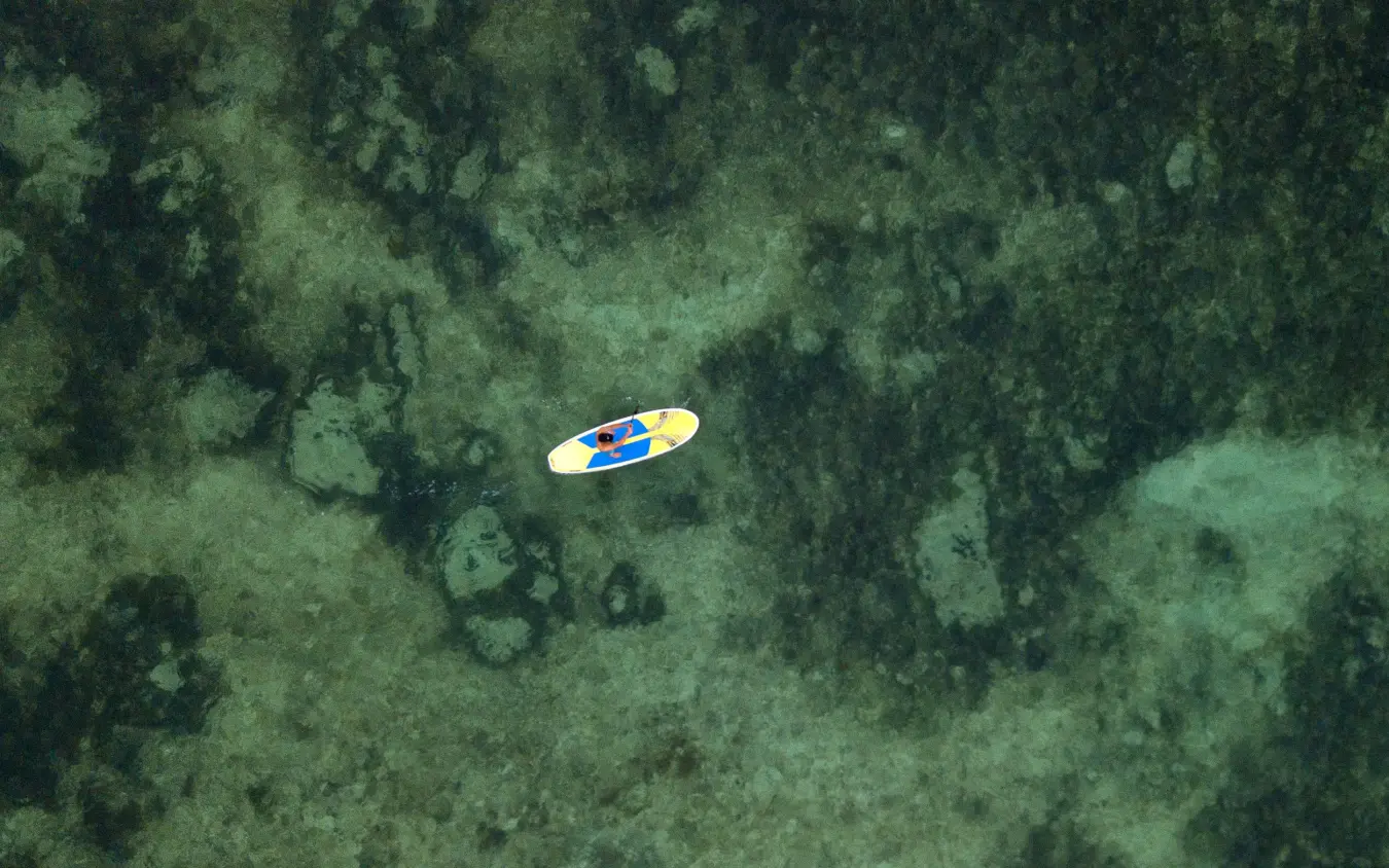 Aerial view of person paddleboarding in shallow turquoise water, Xanadu Villas, Zanzibar & Pemba, Tanzania