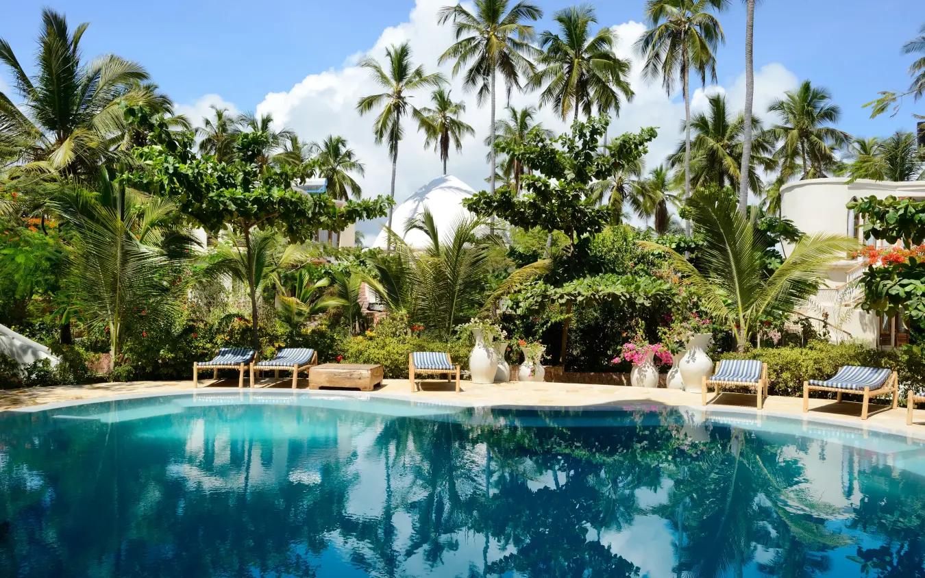 Resort swimming pool with palm trees and lounge chairs, Xanadu Villas, Zanzibar & Pemba, Tanzania