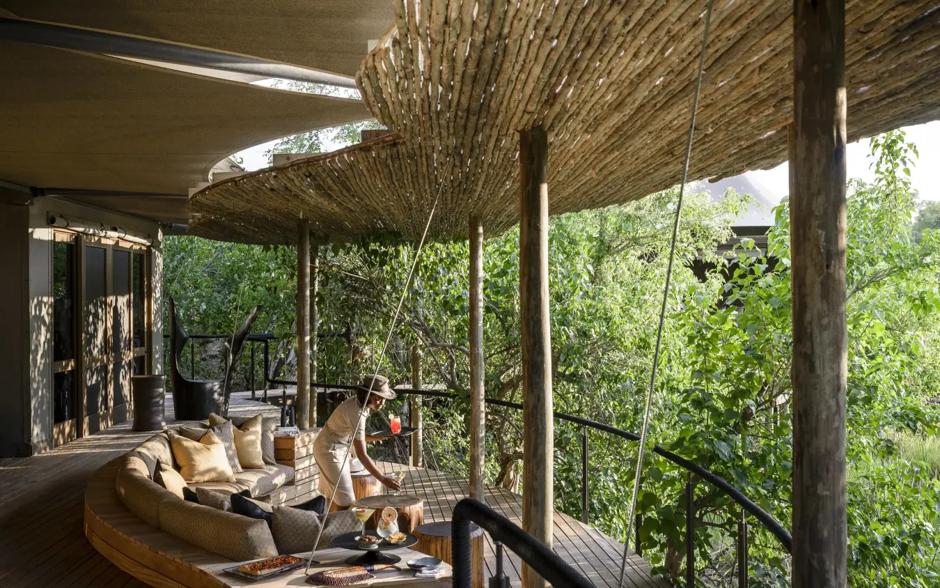 Wooden deck with lounge seating overlooking dense vegetation, Xigera Lodge, The Okavango Delta, Botswana