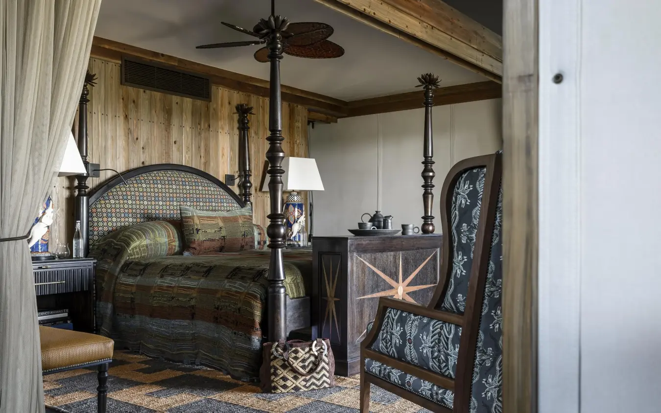 Four-poster bed in luxury bedroom with wooden ceiling beams, Xigera Lodge, The Okavango Delta, Botswana