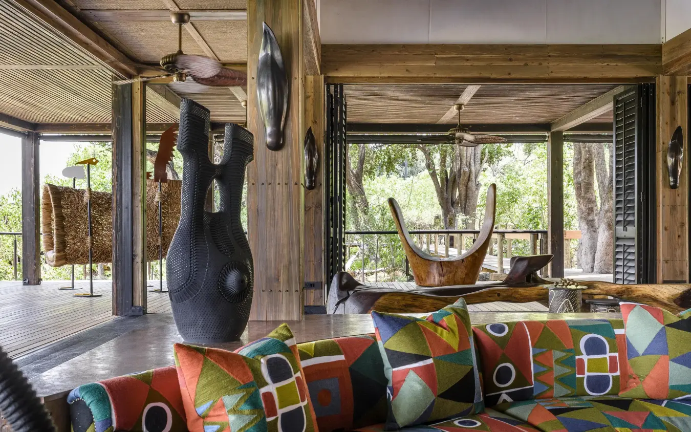 Open-air lounge with colorful patterned seating and sculptures, Xigera Lodge, The Okavango Delta, Botswana