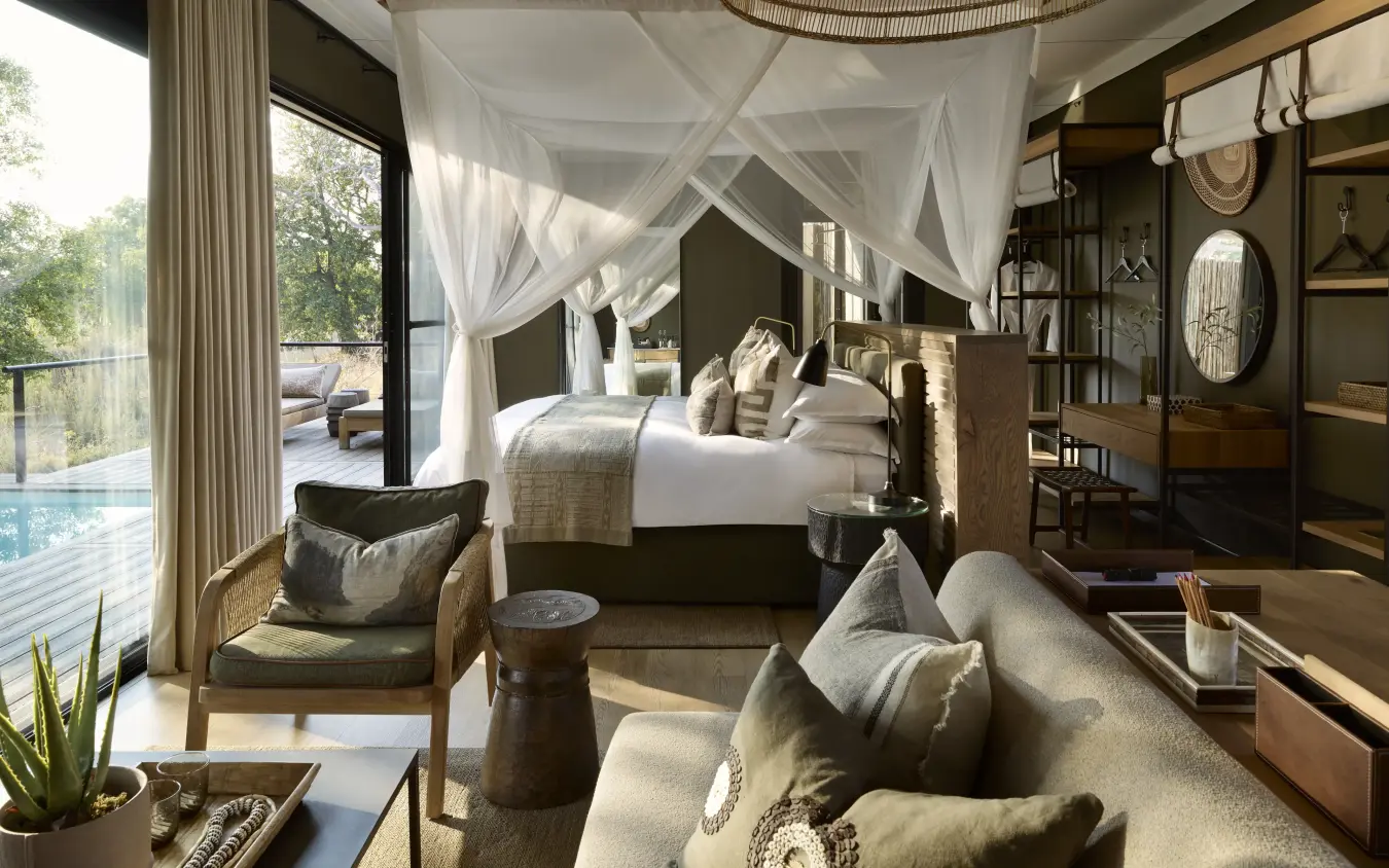 Luxury bedroom suite with canopy bed overlooking pool and landscape, Zambezi Sands, Victoria Falls, Zimbabwe