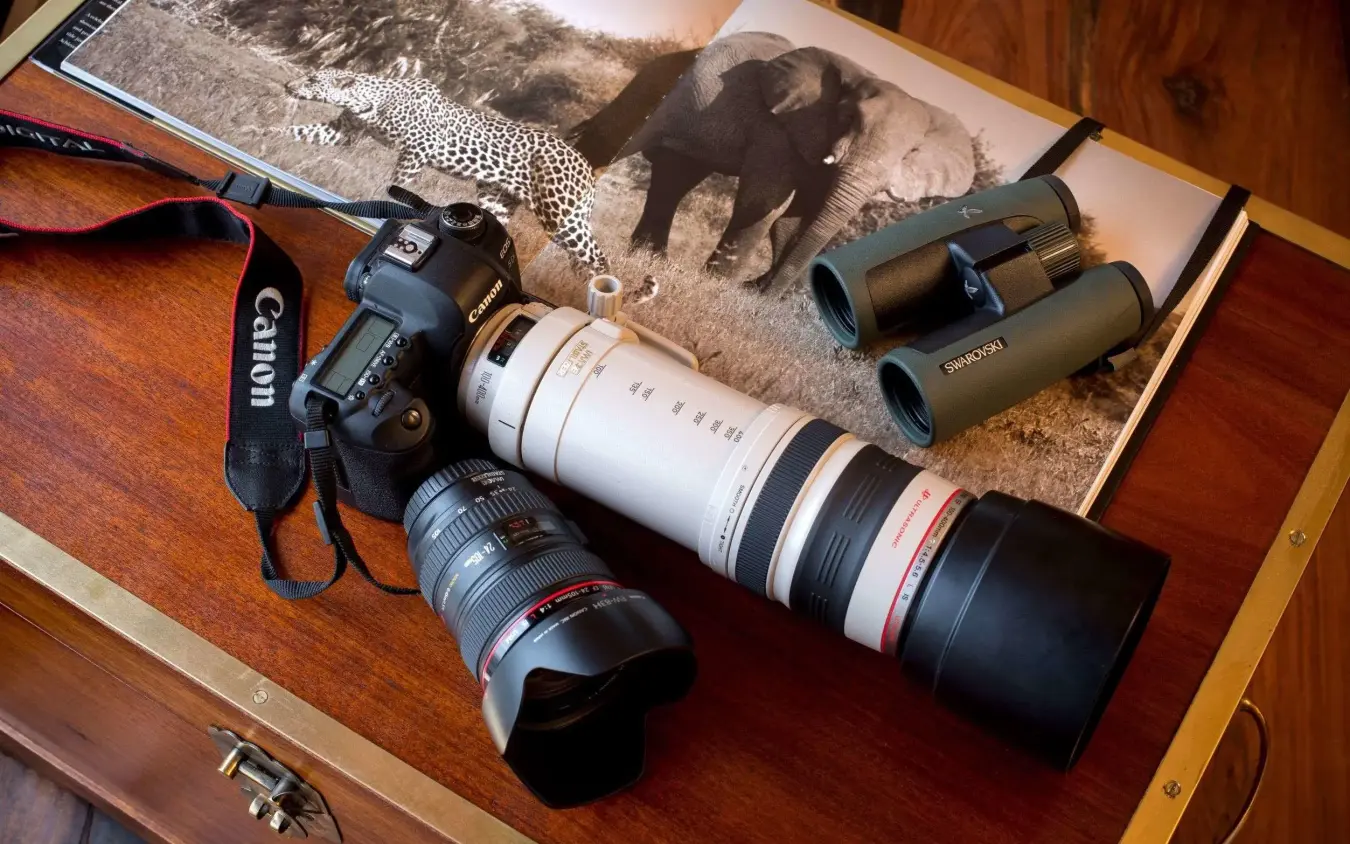 Safari photography equipment displayed with wildlife reference images, Zarafa Camp, Selinda Reserve, Botswana