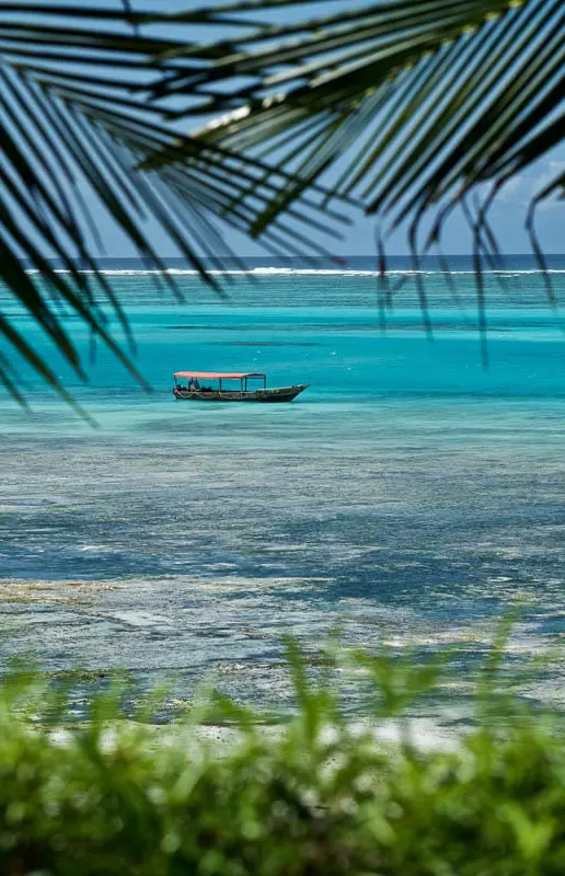Turquoise ocean view with traditional boat anchored offshore, Zawadi Hotel, Zanzibar & Pemba, Tanzania