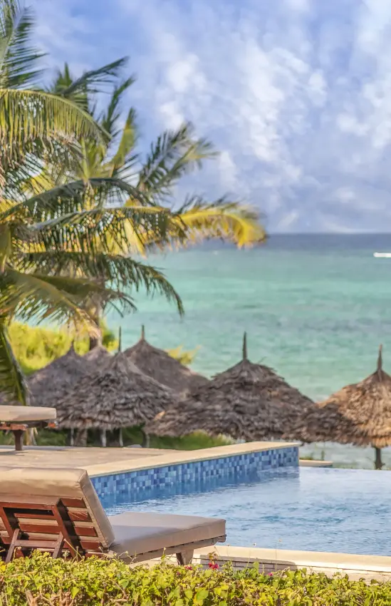 Oceanfront pool deck with loungers and thatched umbrellas, Zawadi Hotel, Zanzibar & Pemba, Tanzania