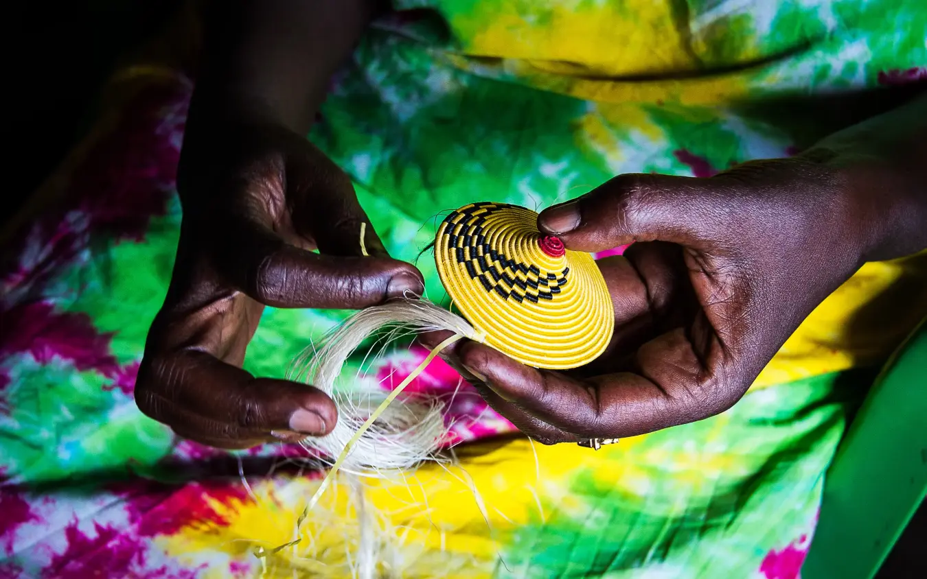Hands holding yellow woven basket with white fibers