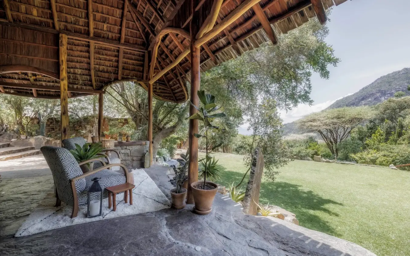 Thatched pavilion with seating overlooking valley and green landscape, Desert Rose, Northern Kenya, Kenya