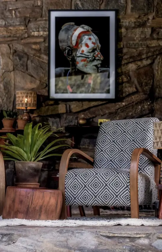 Rustic interior seating area with patterned chair and potted plant against brick wall, Desert Rose, Northern Kenya, Kenya