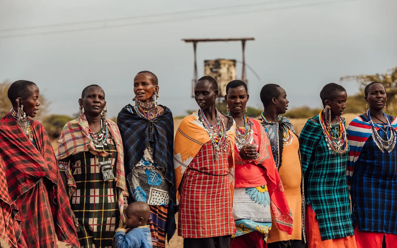 Group of women in traditional beaded dress and colorful patterned cloth wraps, Elephant Gorge Camp, Amboseli and Chyulu Hills, Kenya