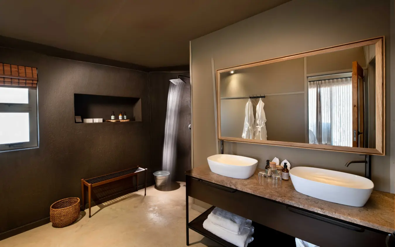 Luxury bathroom with dual vessel sinks and walk-in shower enclosure, Hoanib Elephant Camp, Skeleton Coast, Namibia