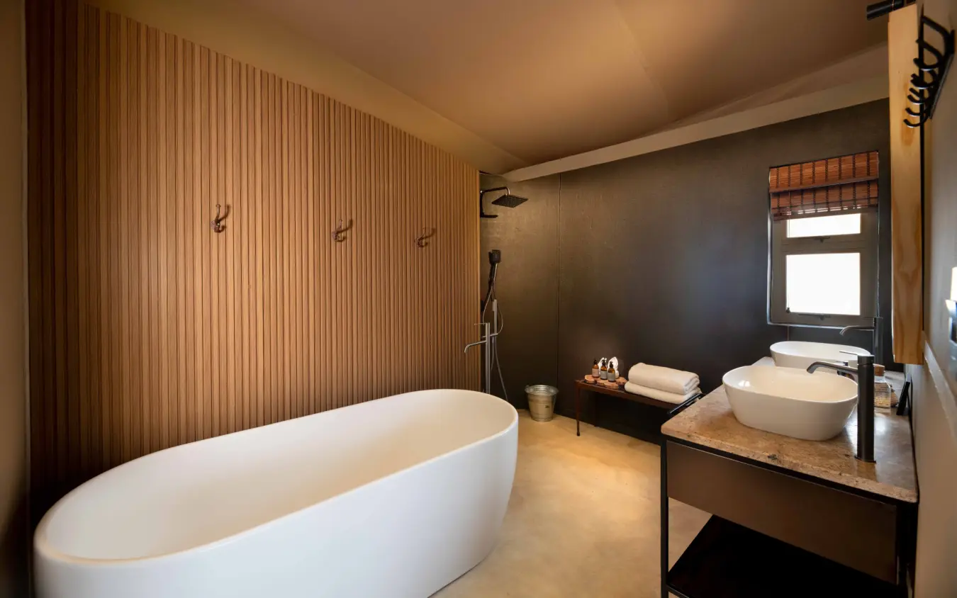 Luxury bathroom with freestanding tub and wooden wall paneling, Hoanib Elephant Camp, Skeleton Coast, Namibia