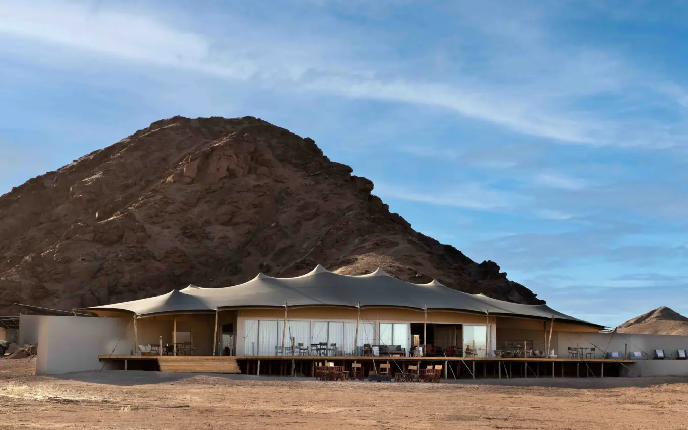 Luxury tent camp with mountain backdrop in desert landscape, Hoanib Elephant Camp, Skeleton Coast, Namibia