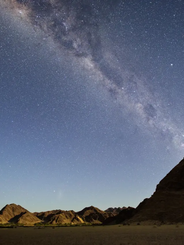 Milky Way galaxy stretching across night sky above desert mountains, Hoanib Elephant Camp, Skeleton Coast, Namibia