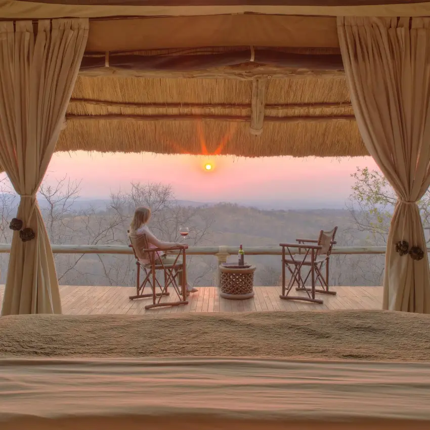 Covered wooden deck overlooking savanna at sunset, Ikuka Safari Camp, Ruaha National Park, Tanzania
