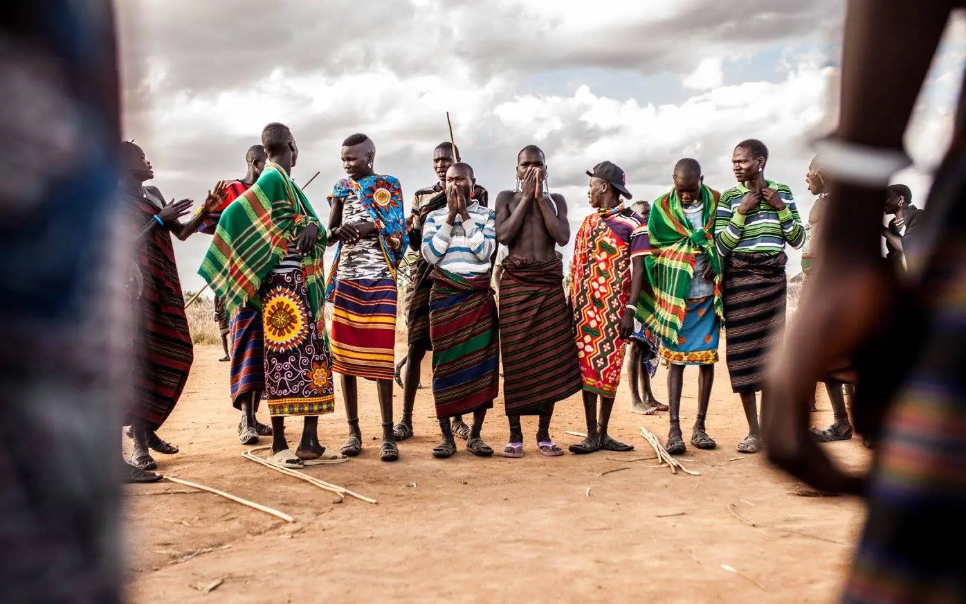 Indigenous warriors gathered in traditional colorful clothing circle