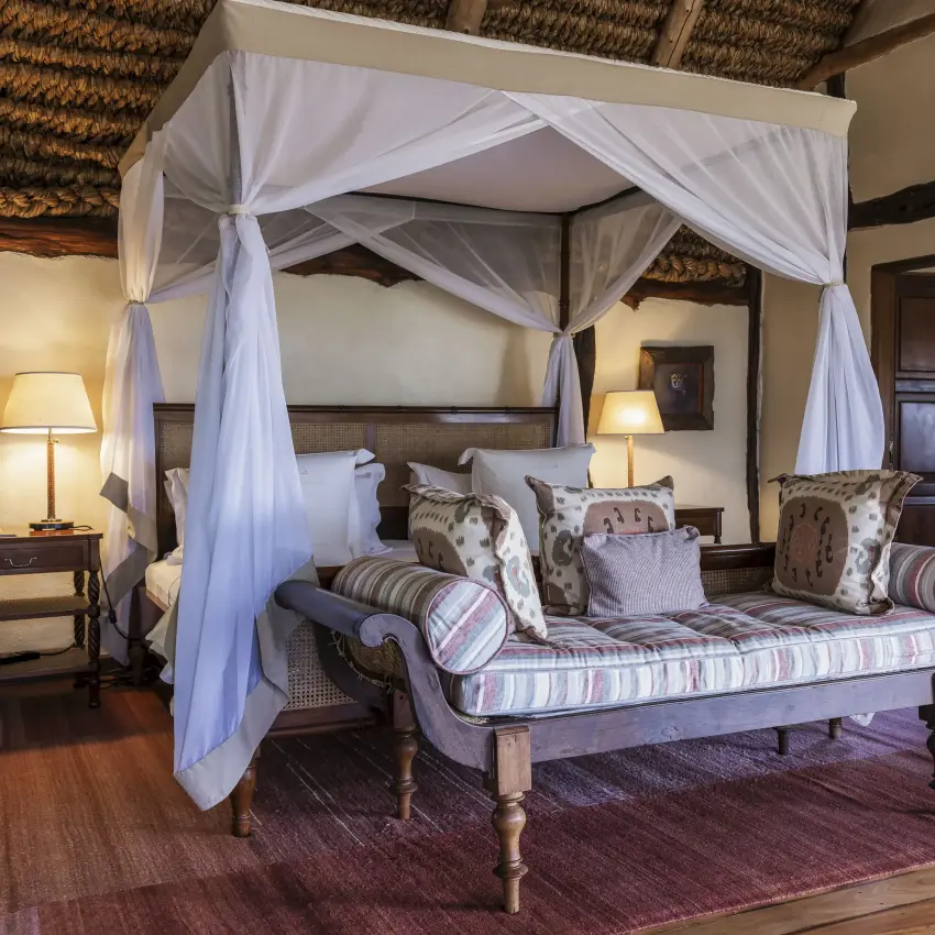 Four-poster canopy bed with white drapes in luxury safari lodge bedroom, Kifaru House, Laikipia Highlands, Kenya