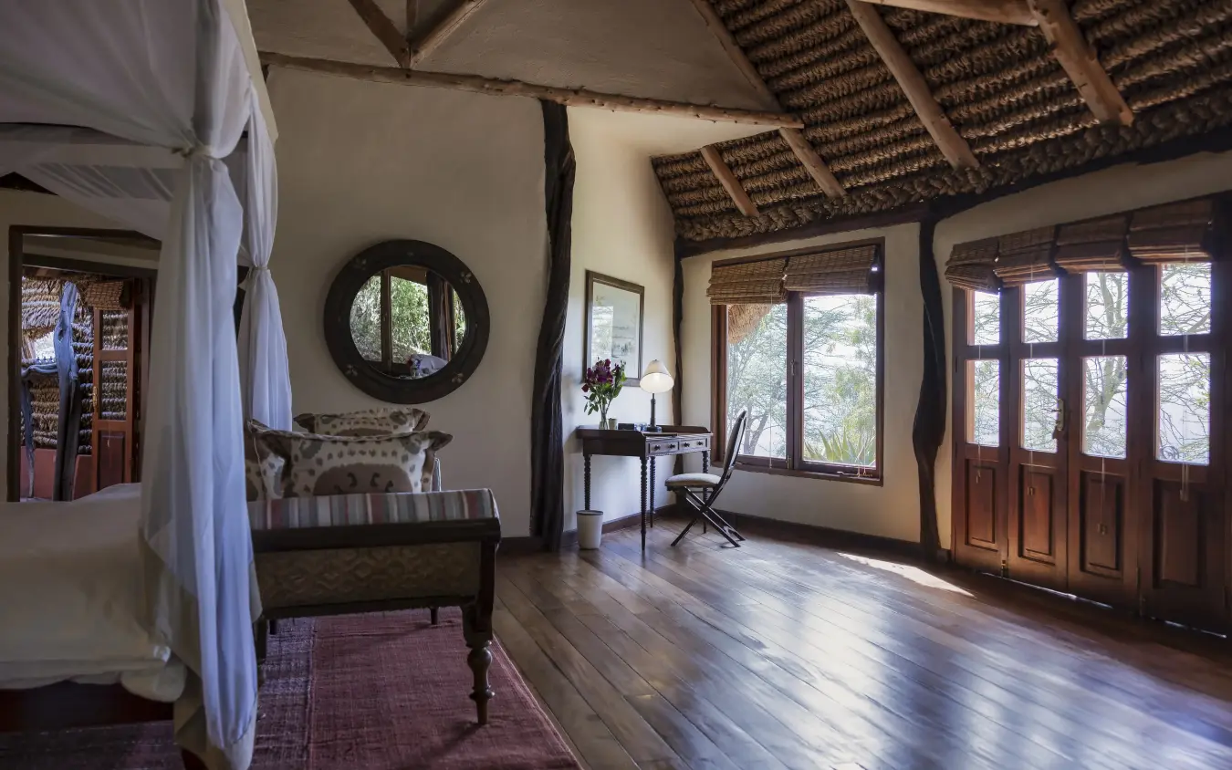 Spacious bedroom suite with thatched ceiling and large windows overlooking woodland, Kifaru House, Laikipia Highlands, Kenya