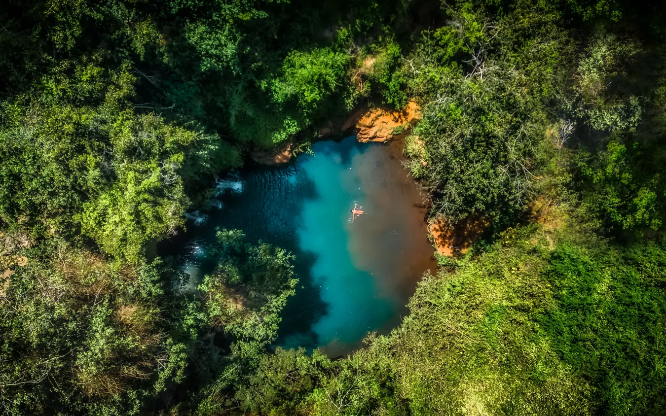 Aerial view of turquoise pool surrounded by dense tropical forest, Kifaru House, Laikipia Highlands, Kenya
