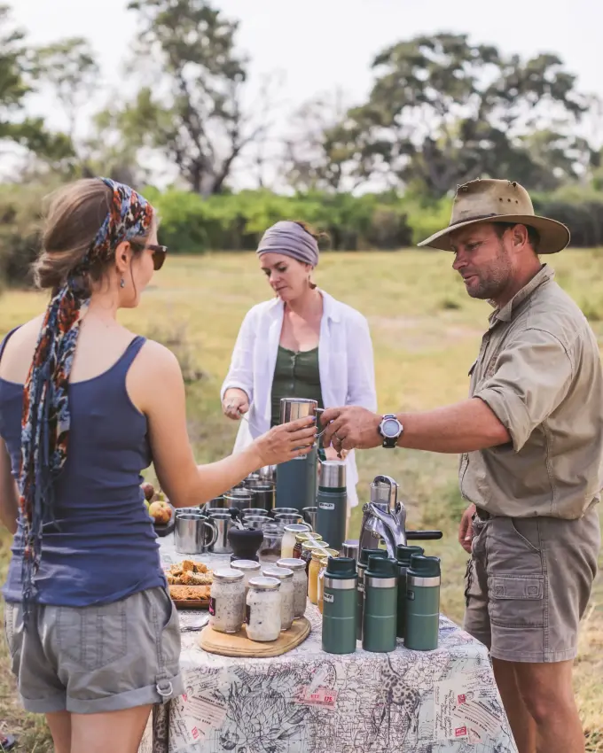 Guides serving refreshments during outdoor safari excursion