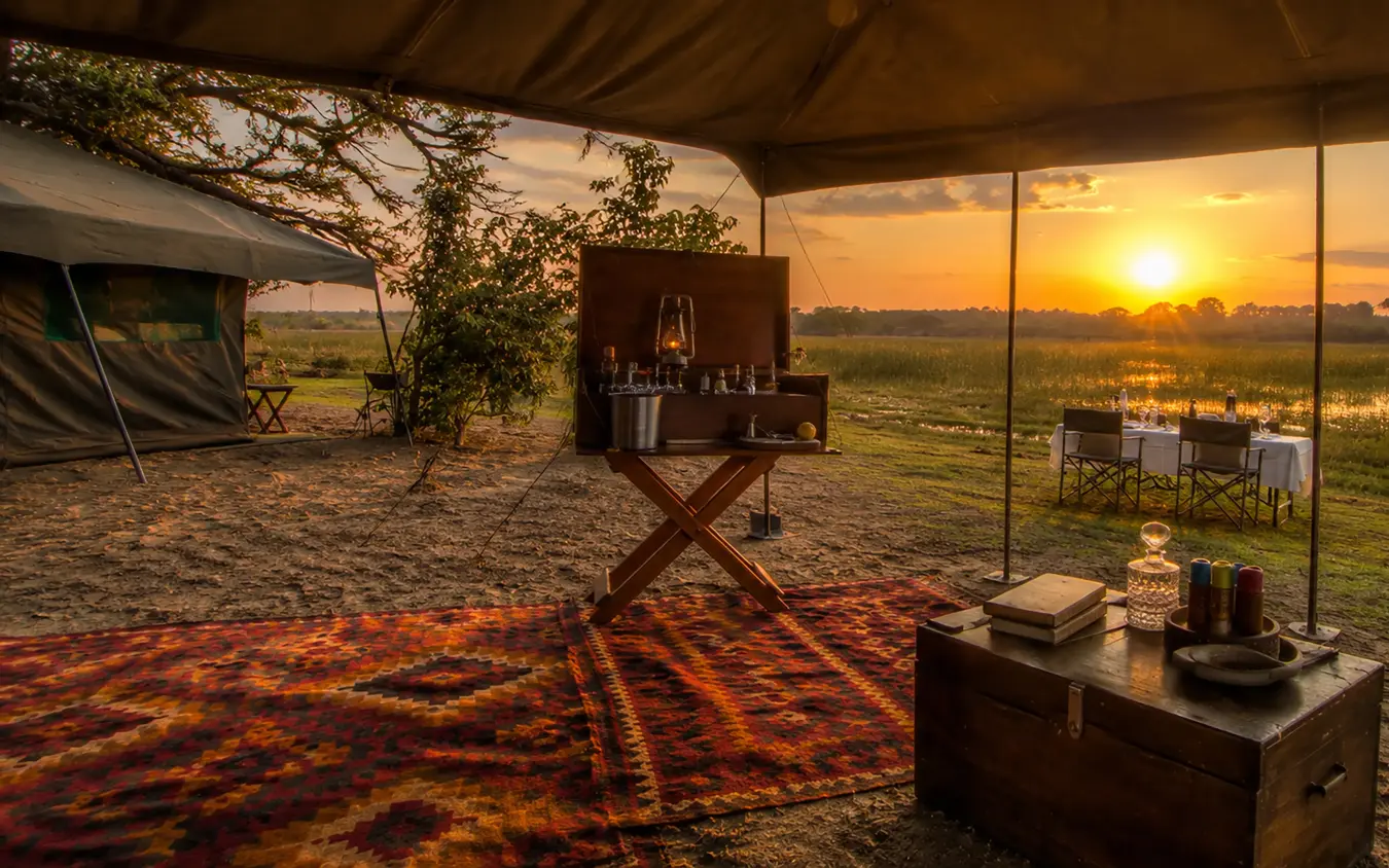 Luxury safari camp interior at sunset overlooking wetland landscape, Zimbabwe