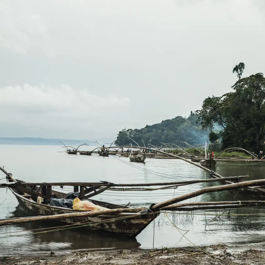 Wooden fishing boats moored in calm lake waters, Nyungwe House, Nyungwe Forest, Rwanda