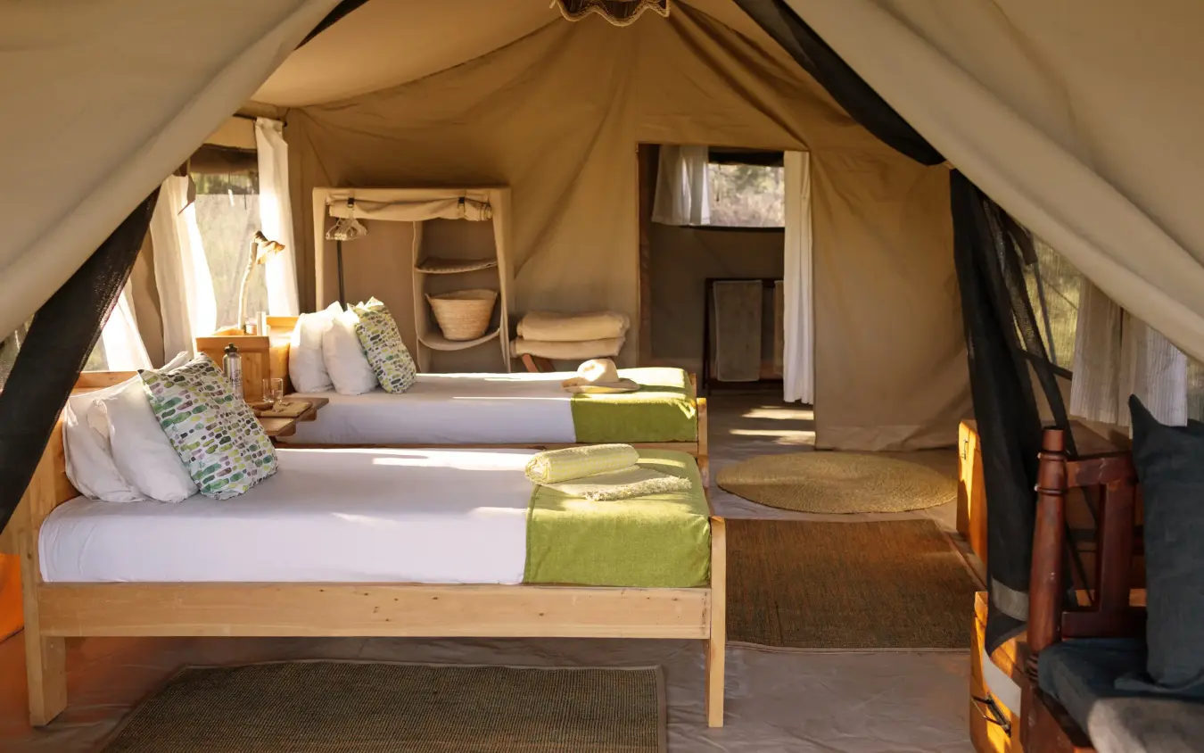 Luxury safari tent interior with twin beds and en-suite bathroom, Serengeti North Wilderness Camp, Serengeti National Park, Tanzania