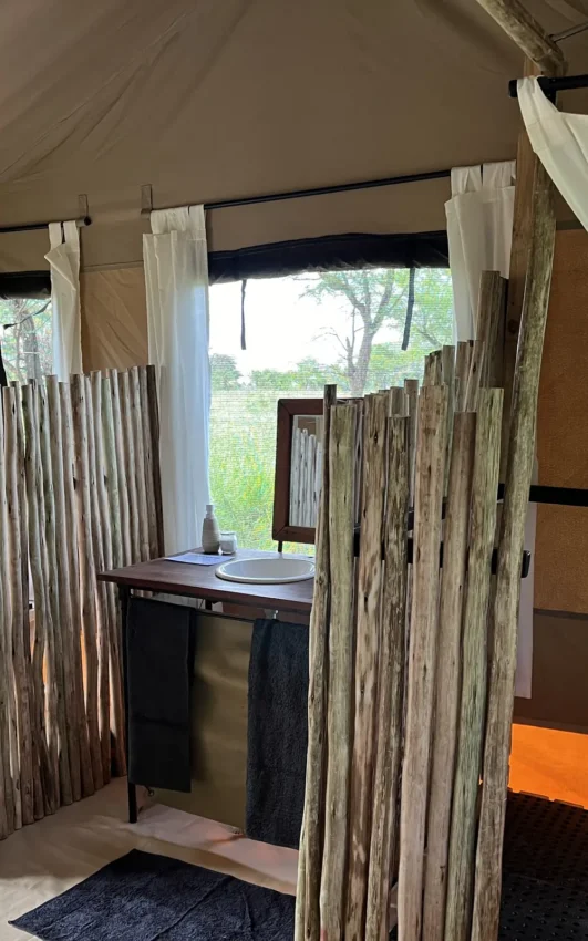 Luxury safari tent bathroom with wooden partition and savanna views, Serengeti Wilderness Camp, Serengeti National Park, Tanzania