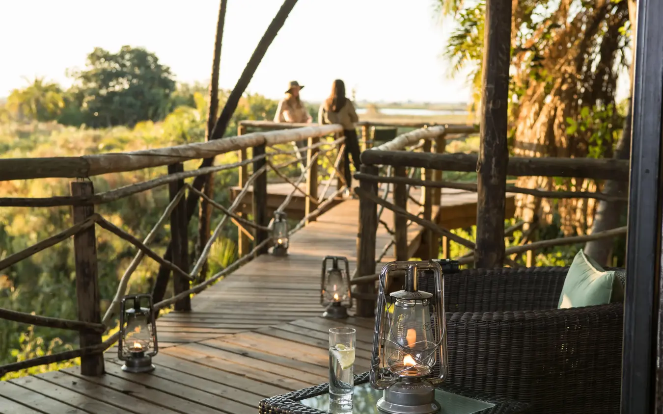 Wooden deck with lanterns overlooking wetland landscape, Setari, The Okavango Delta, Botswana