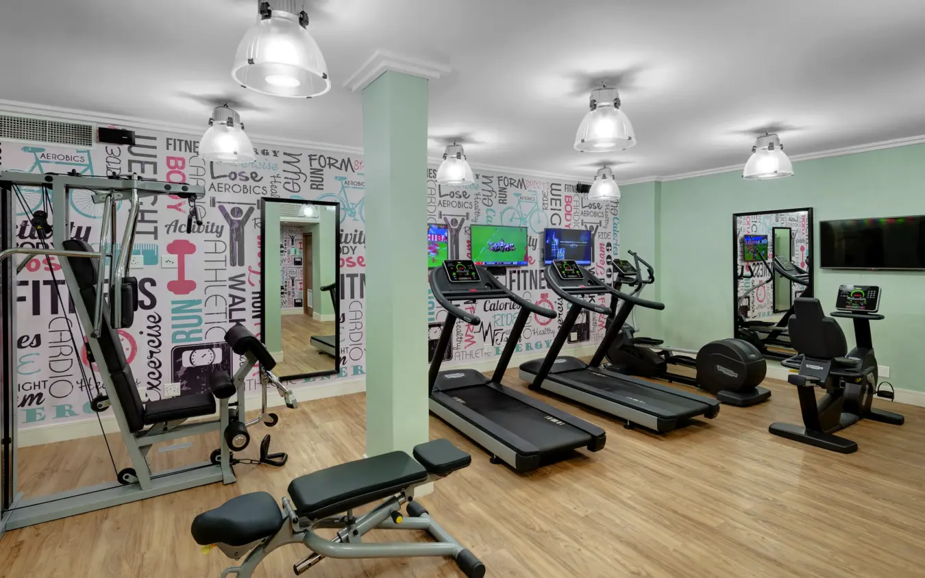 Modern gymnasium with cardio equipment and mint green walls, Strand Hotel Swakopmund, Swakopmund, Namibia