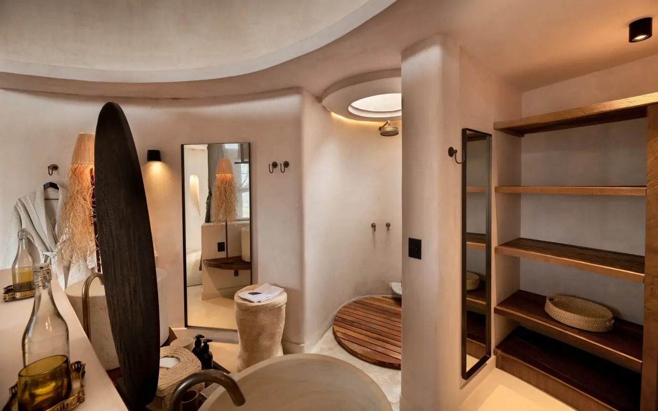 Luxury bathroom suite with curved walls and wooden shelving details, Suyian Lodge, Laikipia Highlands, Kenya