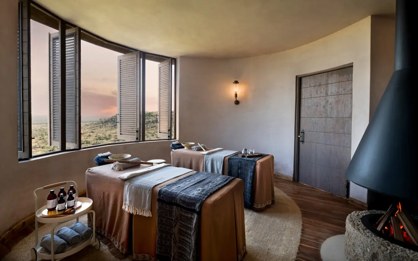 Spa treatment room with dual massage tables overlooking savanna landscape at sunset, Suyian Lodge, Laikipia Highlands, Kenya