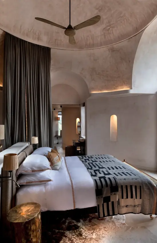 Modern bedroom suite with curved concrete walls and ceiling fan, Suyian Lodge, Laikipia Highlands, Kenya