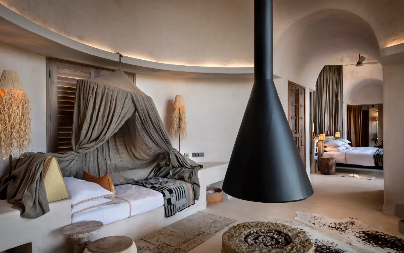 Luxury bedroom suite with conical fireplace and curved architecture, Suyian Lodge, Laikipia Highlands, Kenya