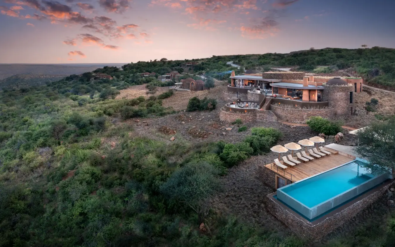 Luxury lodge perched on hillside overlooking vast savanna landscape at dusk, Suyian Lodge, Laikipia Highlands, Kenya